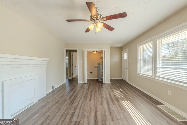 unfurnished living room with light wood-type flooring, visible vents, and baseboards