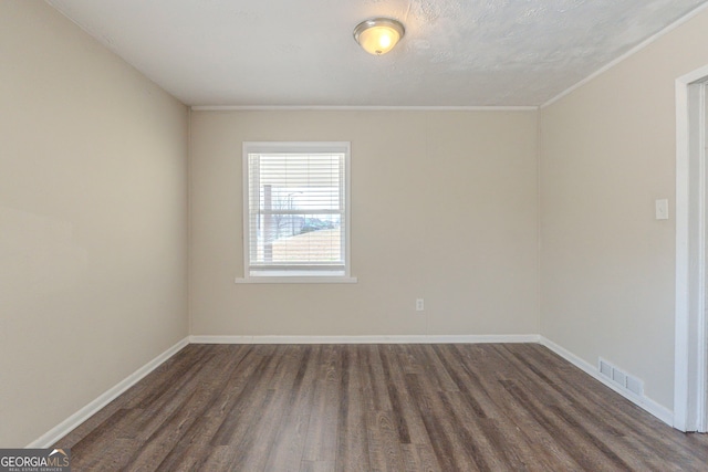 unfurnished room with baseboards, visible vents, and dark wood finished floors