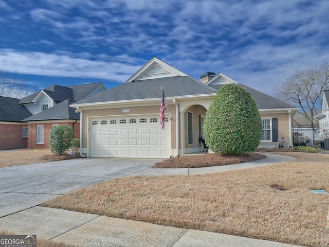 view of front of property with concrete driveway, roof with shingles, an attached garage, and stucco siding