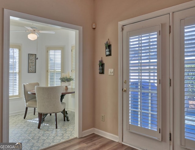 entryway with a ceiling fan, baseboards, and light wood finished floors