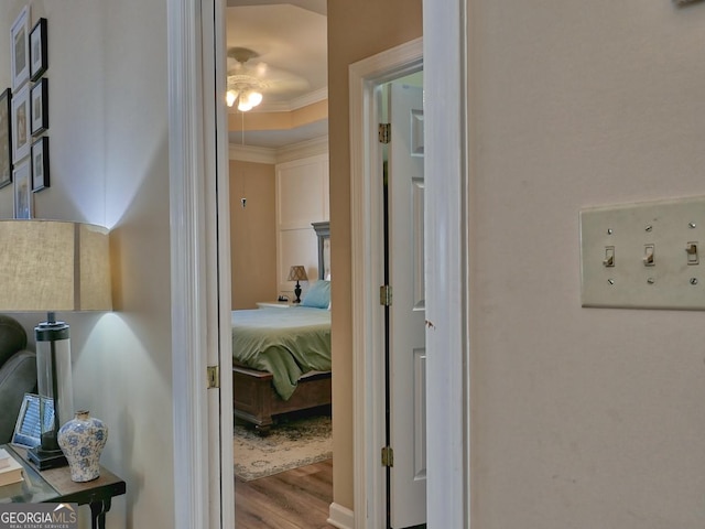 hallway featuring ornamental molding and light wood finished floors