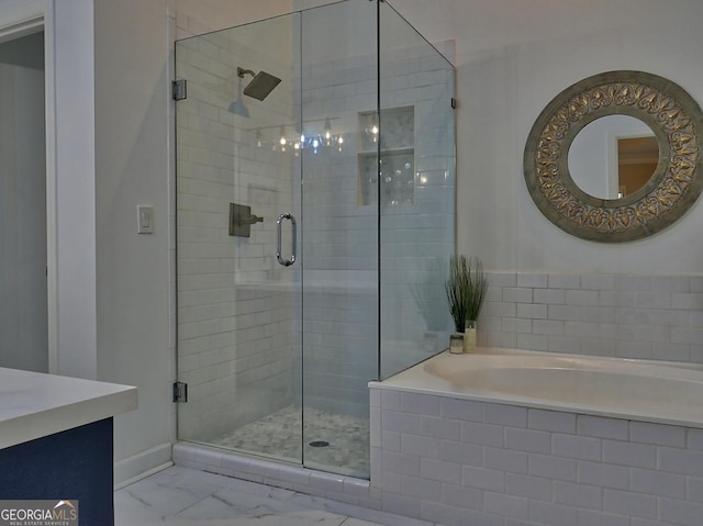 full bathroom featuring marble finish floor, vanity, a bath, and a stall shower