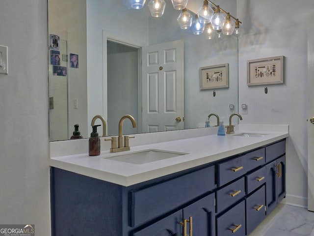 bathroom with marble finish floor, double vanity, a sink, and baseboards