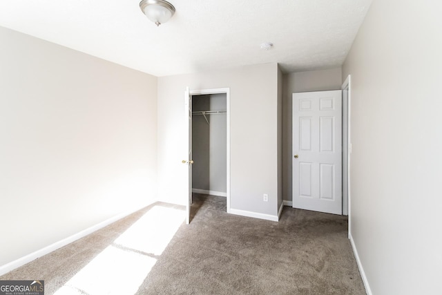 unfurnished bedroom featuring carpet, a closet, and baseboards