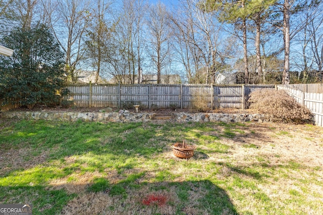 view of yard with an outdoor fire pit and a fenced backyard