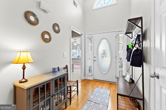 foyer entrance featuring visible vents, a wealth of natural light, and light wood-style flooring