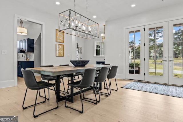 dining space featuring light wood-style floors, recessed lighting, french doors, and baseboards