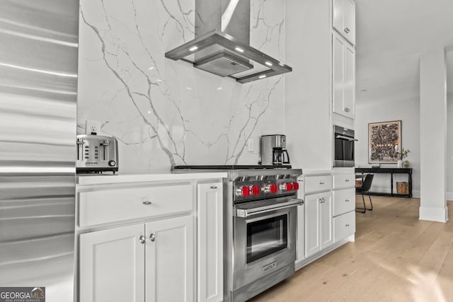 kitchen with white cabinetry, island range hood, high end appliances, and light countertops