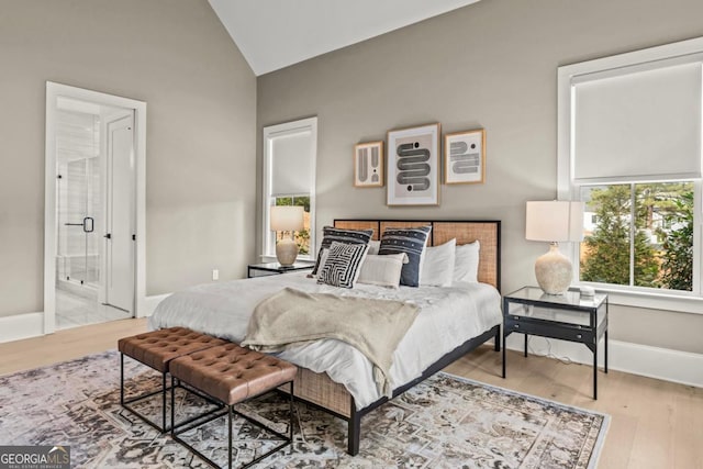 bedroom featuring lofted ceiling, light wood-style floors, and baseboards