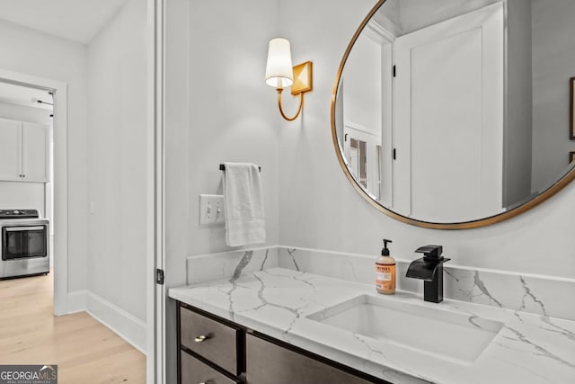 bathroom featuring vanity, baseboards, and wood finished floors