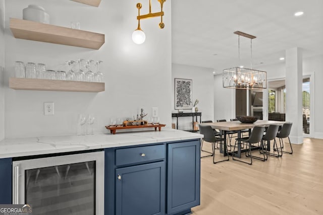 kitchen featuring light stone counters, wine cooler, open shelves, light wood-style flooring, and blue cabinets