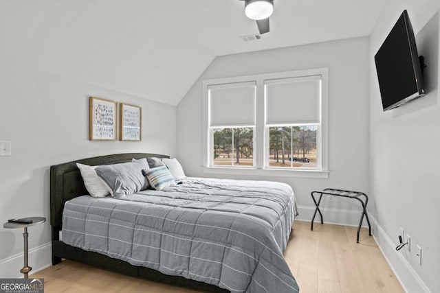 bedroom with visible vents, vaulted ceiling, baseboards, and wood finished floors