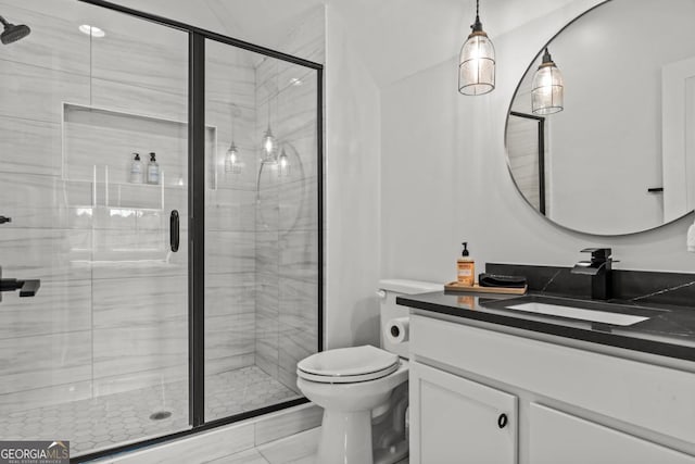 bathroom featuring toilet, a shower stall, and vanity