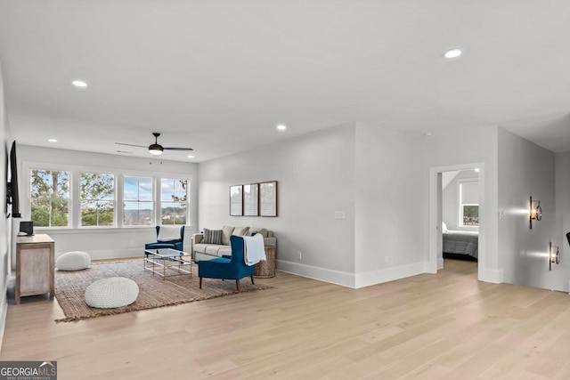 living area featuring a ceiling fan, recessed lighting, light wood-style flooring, and baseboards