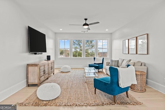 living room featuring light wood-type flooring, ceiling fan, baseboards, and recessed lighting