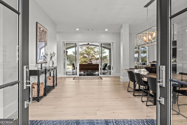 foyer featuring light wood-style flooring, baseboards, a notable chandelier, and recessed lighting