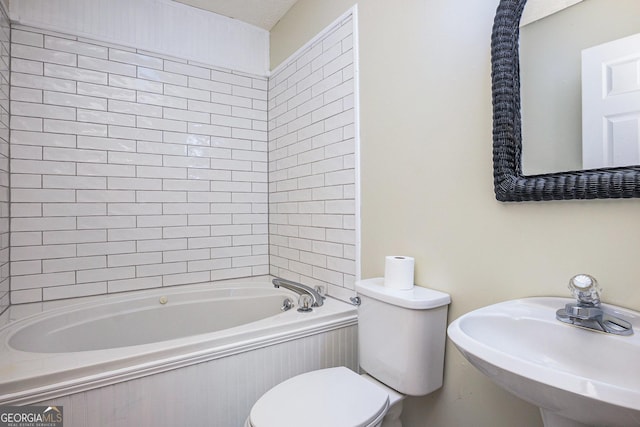 bathroom featuring toilet, a bathing tub, and a sink