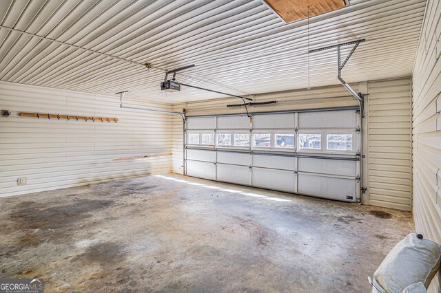 garage with a garage door opener and metal wall