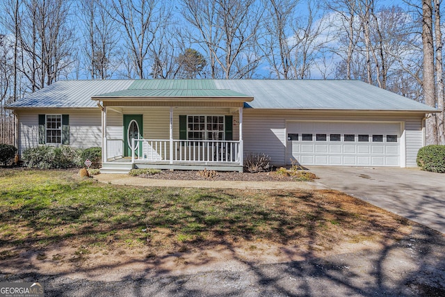 single story home with a porch, an attached garage, a front yard, metal roof, and driveway