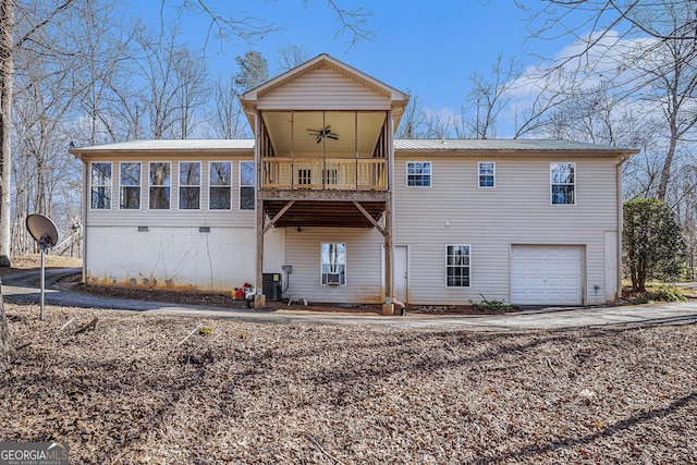 back of house featuring an attached garage, a sunroom, metal roof, and a ceiling fan