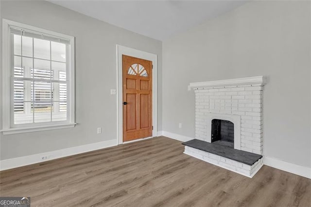 entrance foyer featuring a fireplace, baseboards, and wood finished floors