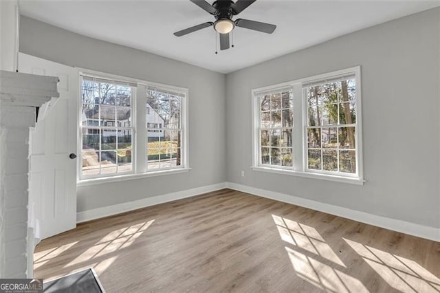 unfurnished room with light wood-type flooring, ceiling fan, and baseboards