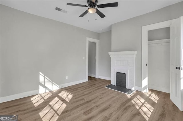 unfurnished living room with dark wood-style floors, baseboards, a fireplace, and visible vents