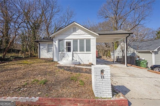 bungalow with a carport, brick siding, and driveway