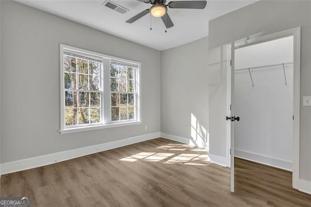 unfurnished bedroom featuring a closet, wood finished floors, and visible vents