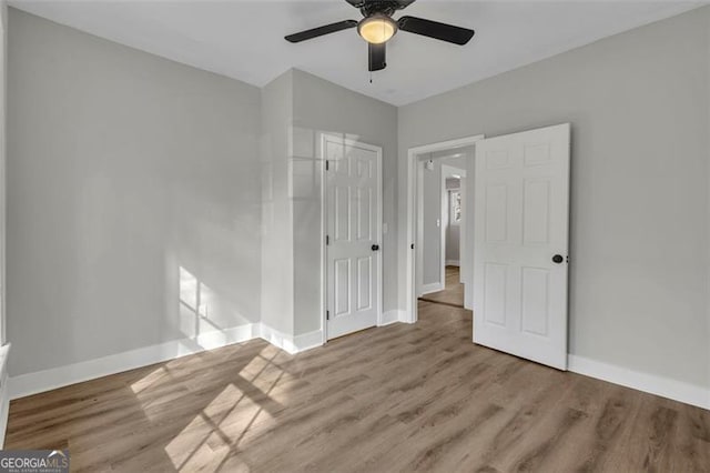 unfurnished bedroom with a ceiling fan, light wood-style flooring, baseboards, and a closet