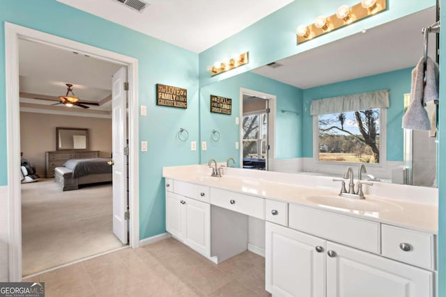 ensuite bathroom featuring a ceiling fan, double vanity, a sink, and ensuite bathroom