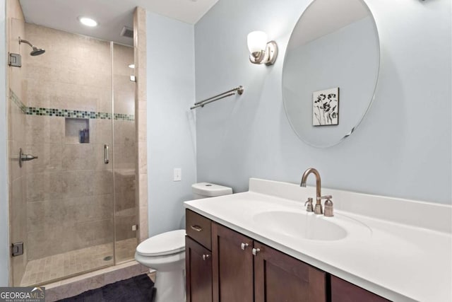 bathroom featuring toilet, a shower stall, tile patterned flooring, and vanity