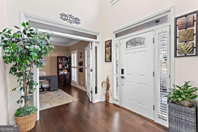 foyer with baseboards, dark wood finished floors, and crown molding