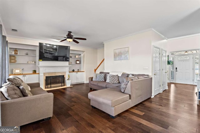 living area with a fireplace with flush hearth, visible vents, dark wood finished floors, and crown molding