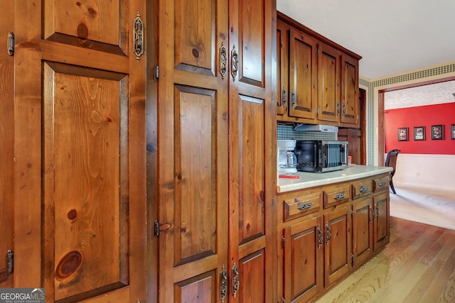 kitchen with light countertops, light wood-style flooring, and brown cabinets