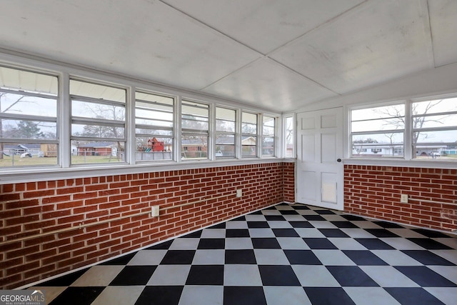 unfurnished sunroom featuring vaulted ceiling