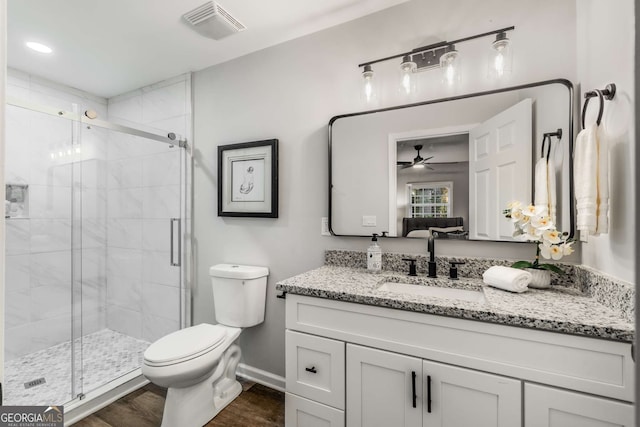 bathroom with a stall shower, visible vents, vanity, and toilet