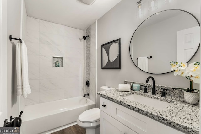 bathroom featuring wood finished floors, bathing tub / shower combination, vanity, and toilet