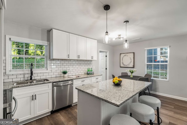 kitchen with tasteful backsplash, dishwasher, a sink, and dark wood-style floors