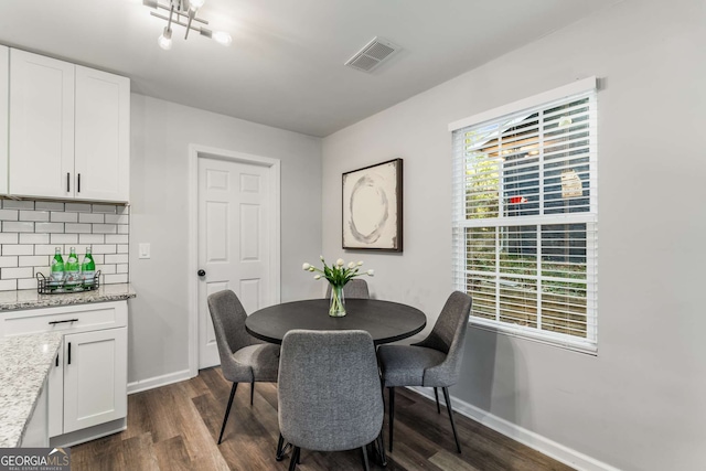 dining space with dark wood finished floors, visible vents, and baseboards