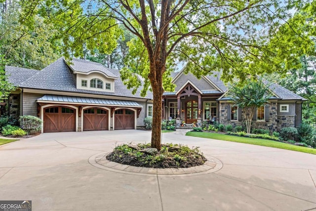 view of front of house with roof with shingles, curved driveway, and an attached garage