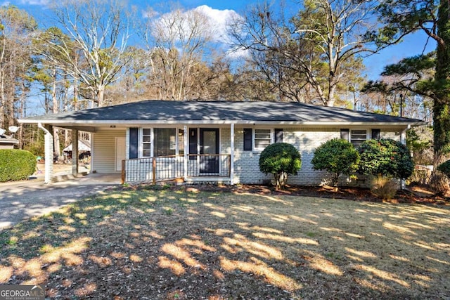 single story home featuring driveway, a porch, an attached carport, and brick siding