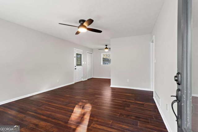 unfurnished room with baseboards, dark wood finished floors, and a ceiling fan