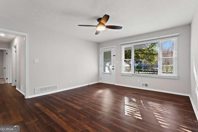 interior space featuring visible vents, dark wood finished floors, and baseboards