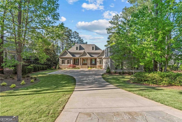 view of front facade featuring driveway, a porch, and a front yard