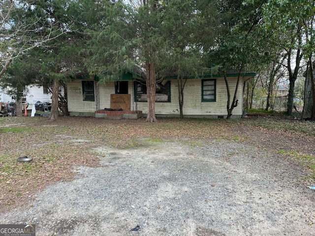 view of front facade featuring crawl space and gravel driveway