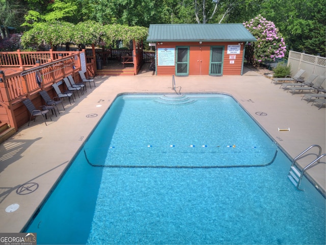 527 Hidden Valley Rd Unit 189, Cleveland, GA 30528 - community pool with fence, a wooden deck, an outdoor structure, a patio area, and view of wooded area
