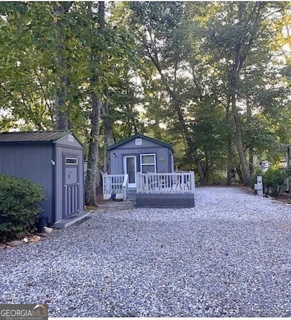 527 Hidden Valley Rd Unit 189, Cleveland, GA 30528 - back of property featuring a shed, an outbuilding, a wooden deck, and view of scattered trees