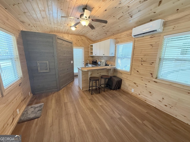 527 Hidden Valley Rd Unit 189, Cleveland, GA 30528 - kitchen with a wall unit AC, wood walls, vaulted ceiling, open shelves, and a breakfast bar area