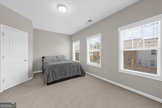 bedroom featuring visible vents, baseboards, and carpet